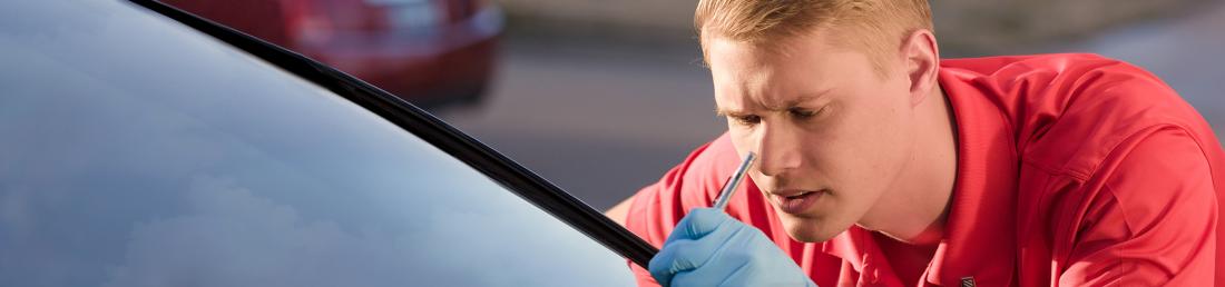 Closeup of a Glass Doctor specialist repairing a crack in a windshield